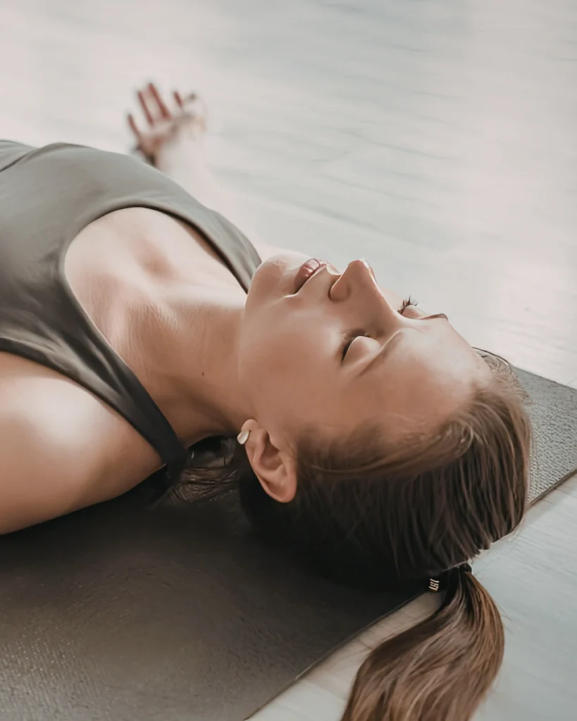 Woman lying calmly on a mat during a guided TRE® session